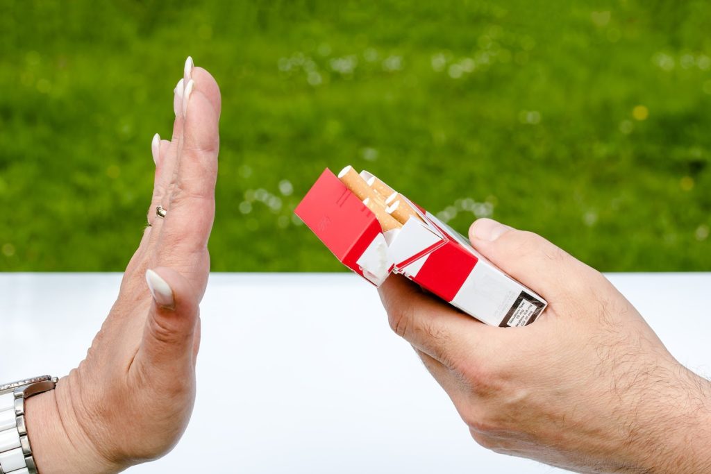 Woman holding out hand to stop someone offering cigarettes