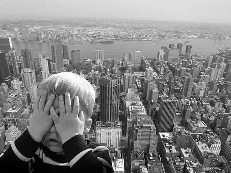 Child covering eyes from fear of heights 