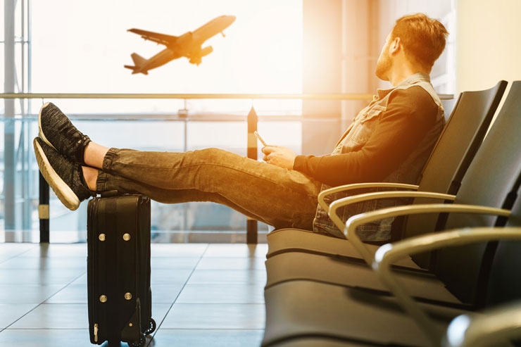 Man sitting at airport terminal looking at plane