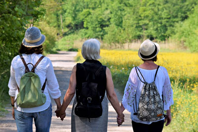 Three women holding hands while walking