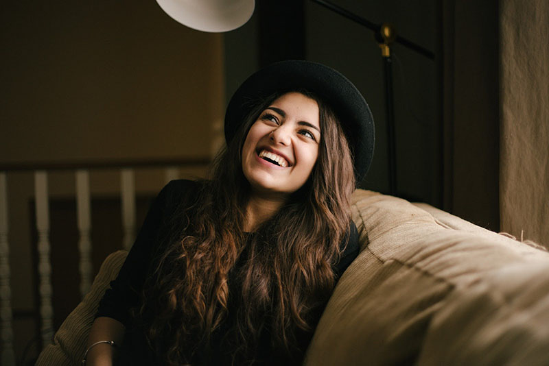 Smiling woman on a couch during therapy learning what therapy is best for her