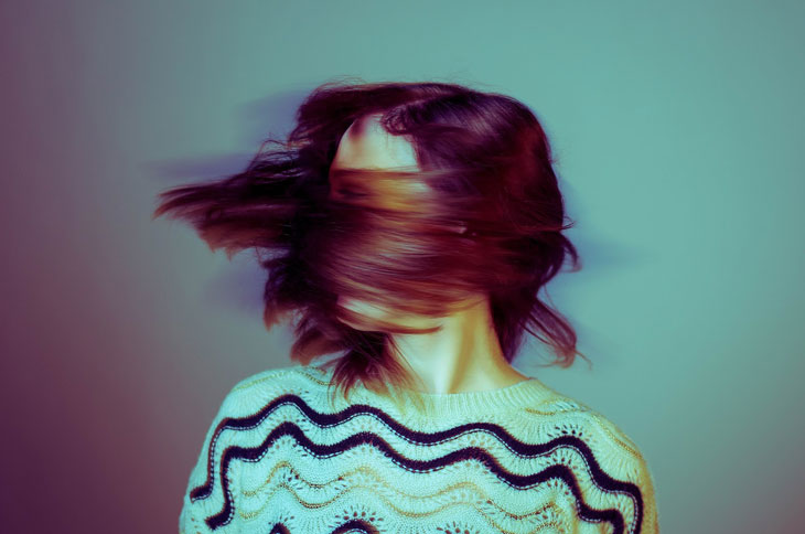 Young person shaking head fast with hair across her face