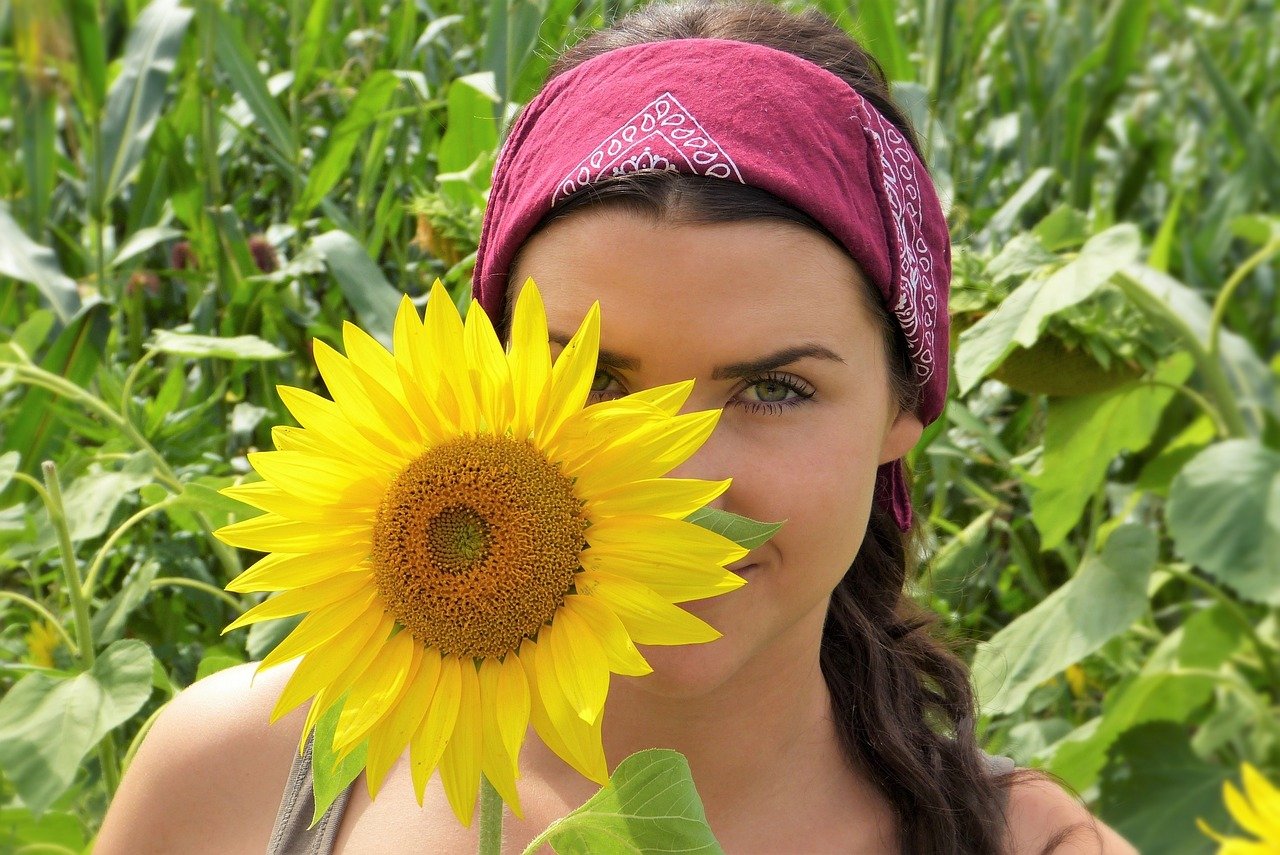 A happy teen girl holding a sunflower