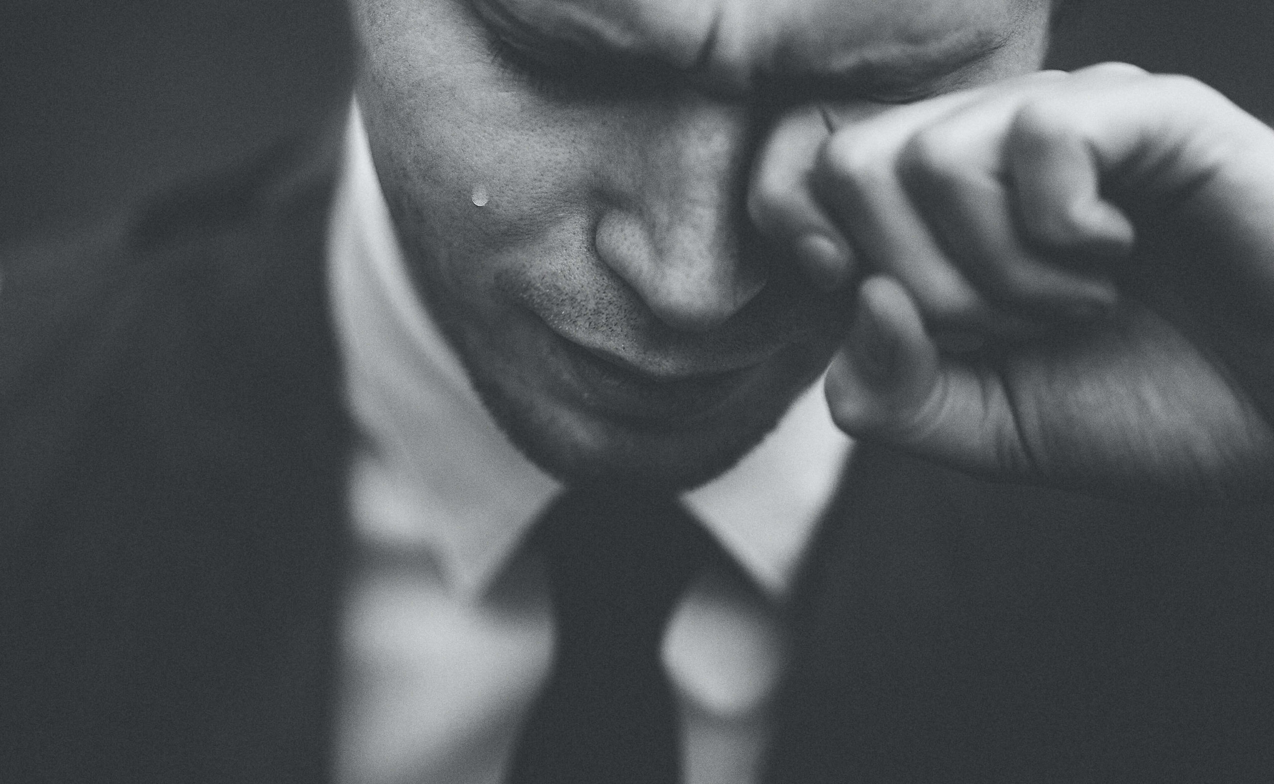 Black and white photo of a man upset wearing a suit