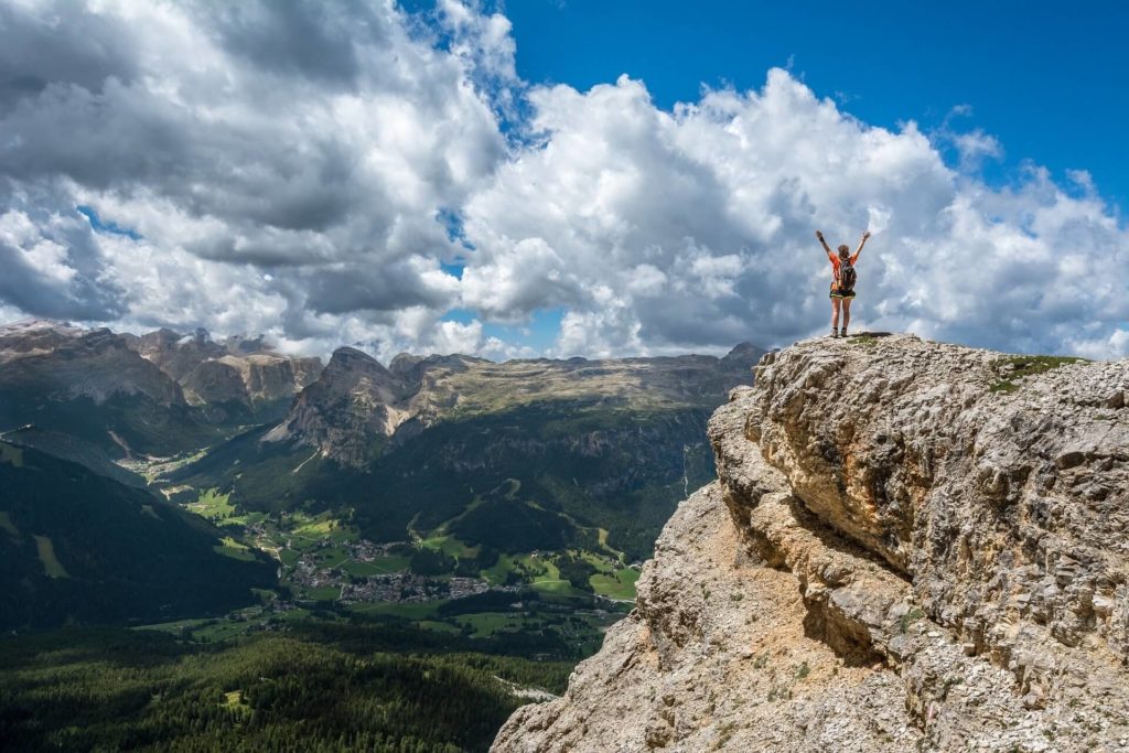 Person with hands in the air on top of a mountain