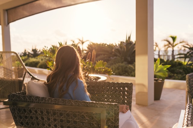 Woman sitting on outdoor veranda peacefully