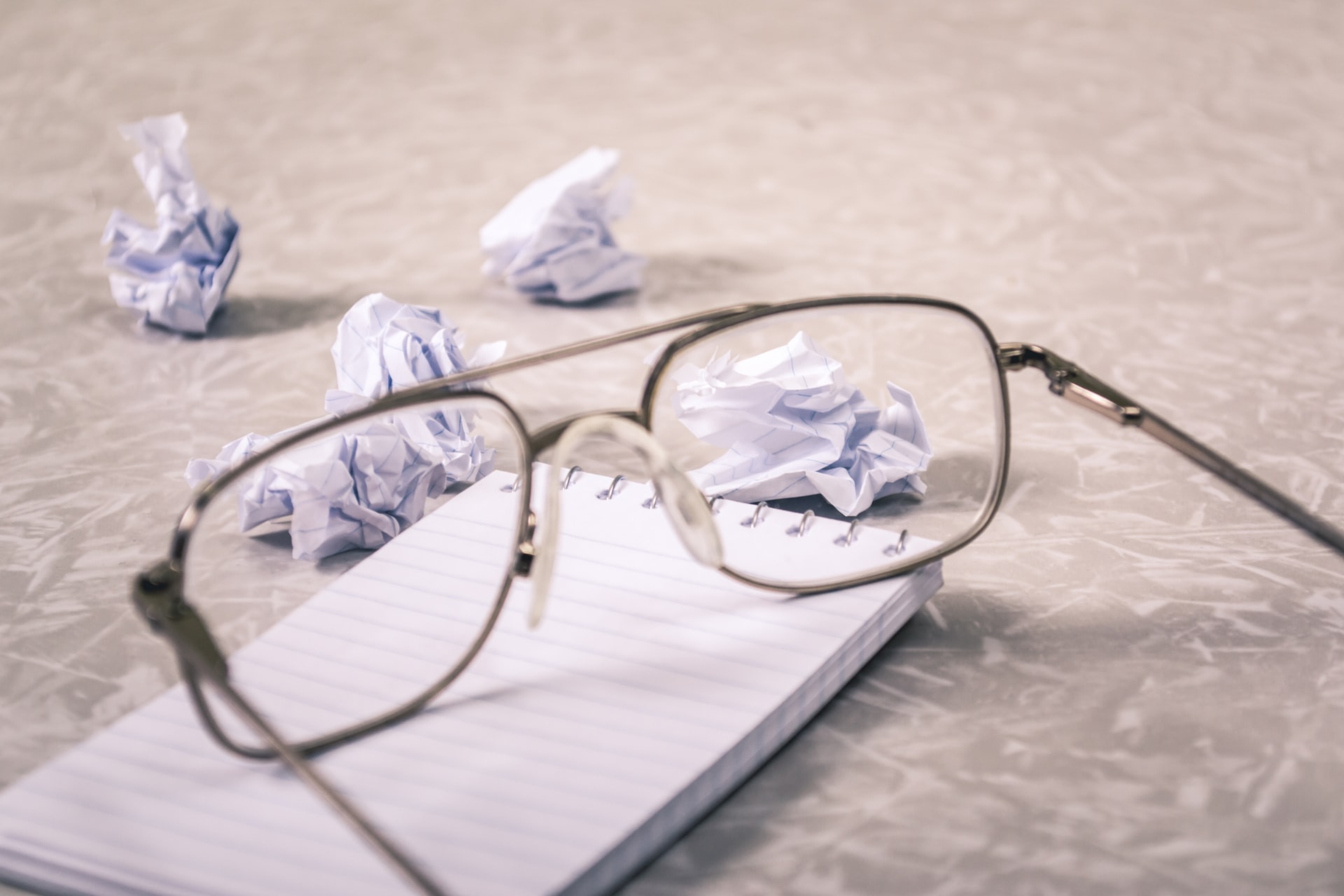 eyeglasses with notebook and crumpled paper