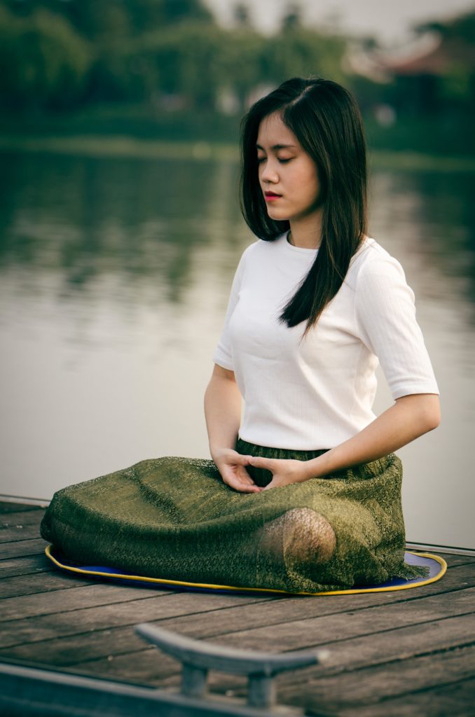 Woman meditating by the water