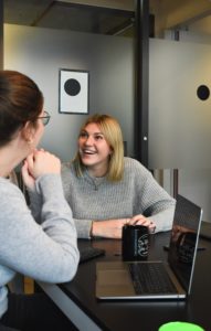 Two co-workers being productive and smiling at work