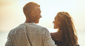 couple smiling in front of ocean