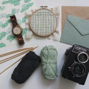 Knitting supplies, photography supplies, and paper goods on a table
