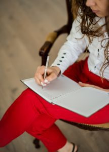 Woman with red pants taking notes