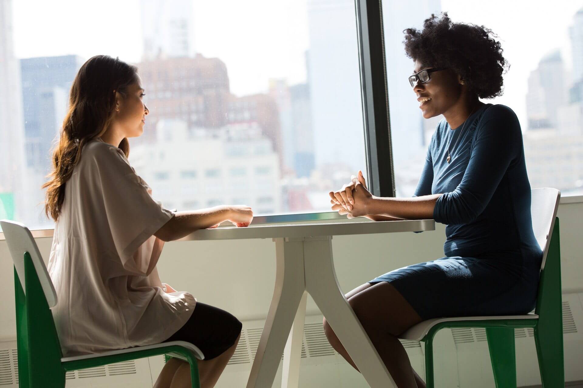 Two women sitting at a table across from each other