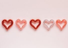 Row of five hearts in shades of red, pink, and white