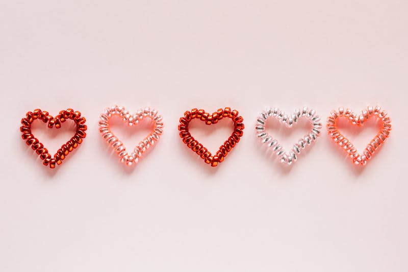 Row of five hearts in shades of red, pink, and white