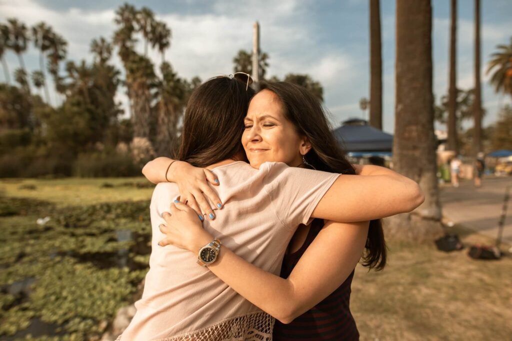 Two women hugging in a park