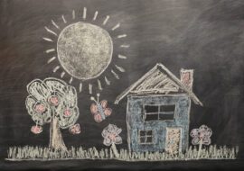 Chalk drawing on a blackboard of a person’s childhood home with trees and a sun