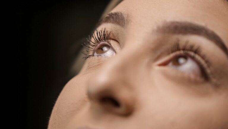 A close-up of a woman’s brown eyes as she looks up