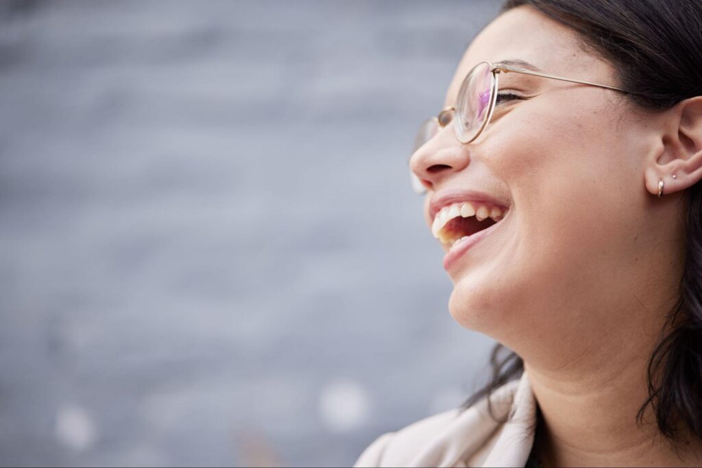 A smiling woman in glasses feeling positive and focused